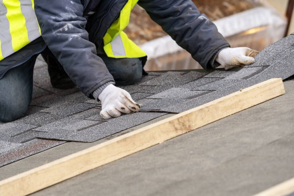 Workman install tile on roof of new house under construction