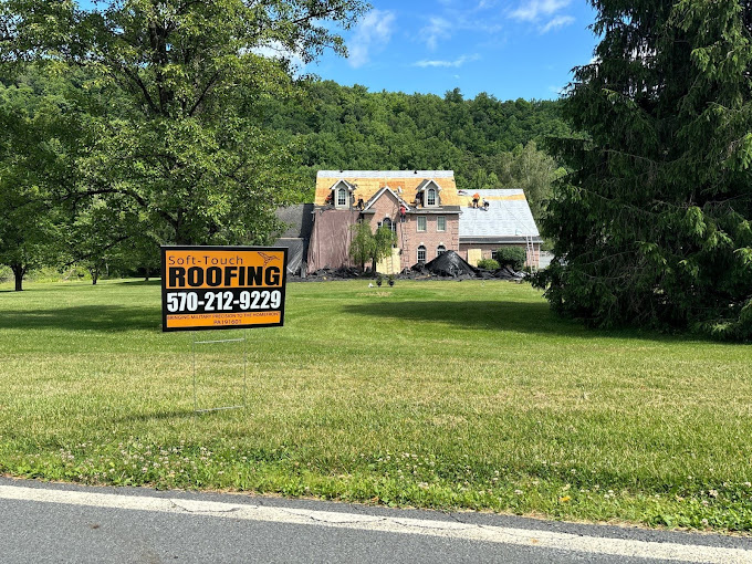 Soft-Touch Roofing yard sign in front of roof replacement client's house.